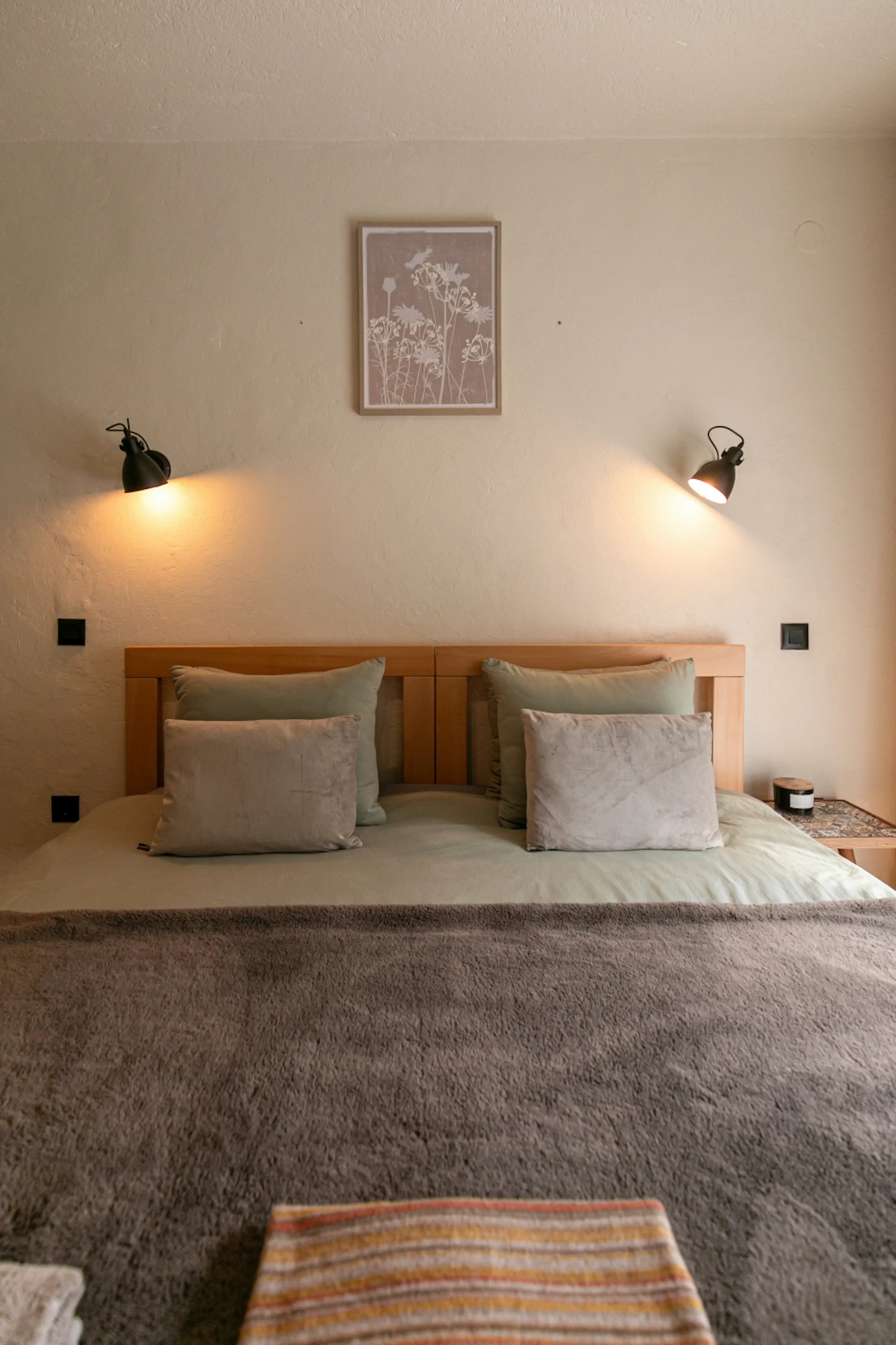 Sunny balcony with wooden outdoor furniture, colorful bunting flags, and stunning Montenegro mountain range panorama from Fireside Lodge