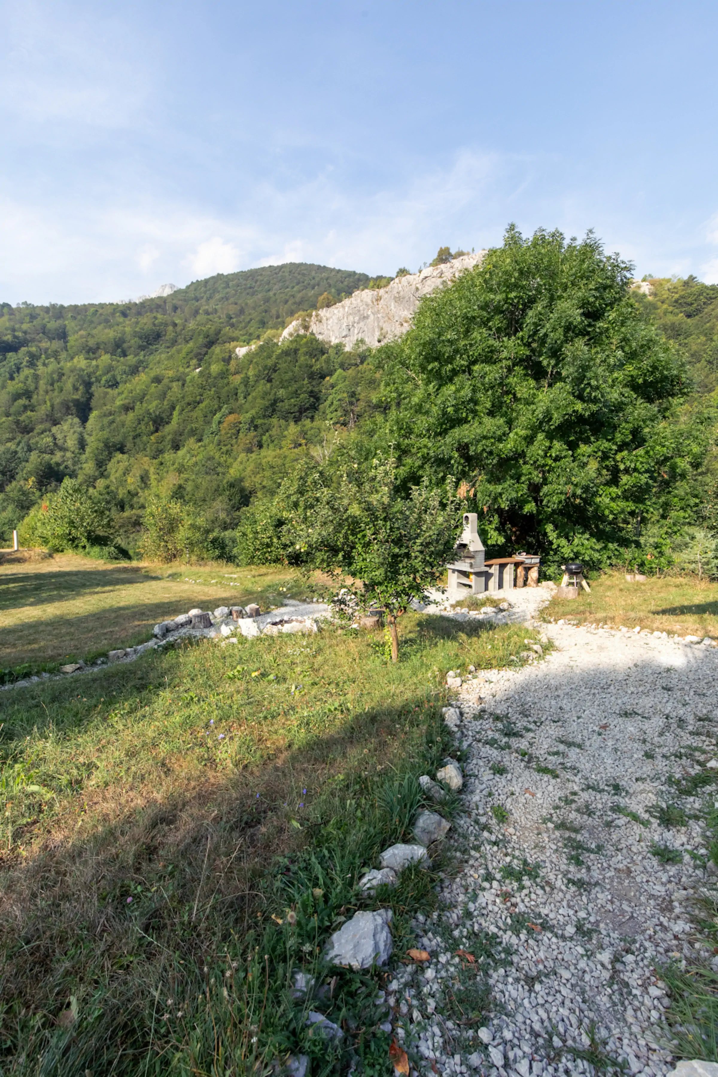 Outdoor BBQ area with panoramic mountain cliff views and green meadows in Lipovo Valley Montenegro